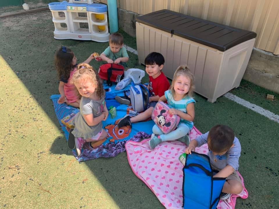 Group of children sitting on blankets outdoors