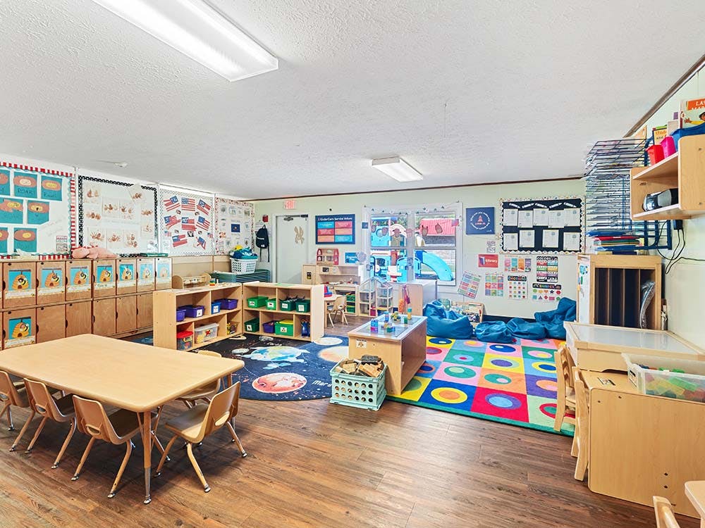 Empty colorful preschool classroom with small tables and chairs
