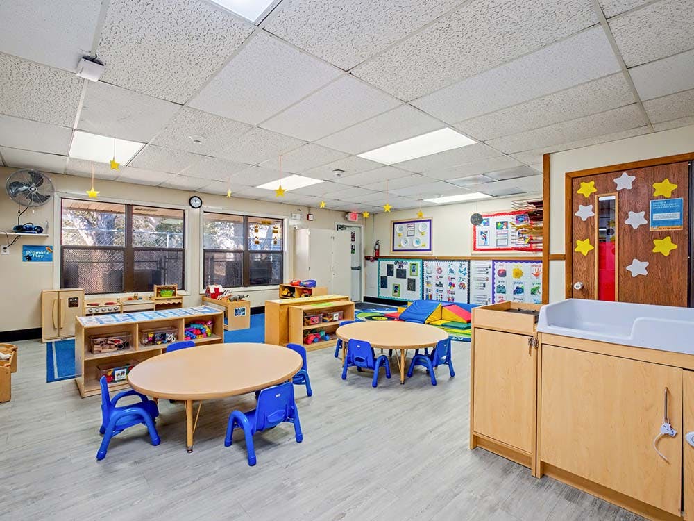 Empty colorful children's classroom with small tables and chairs