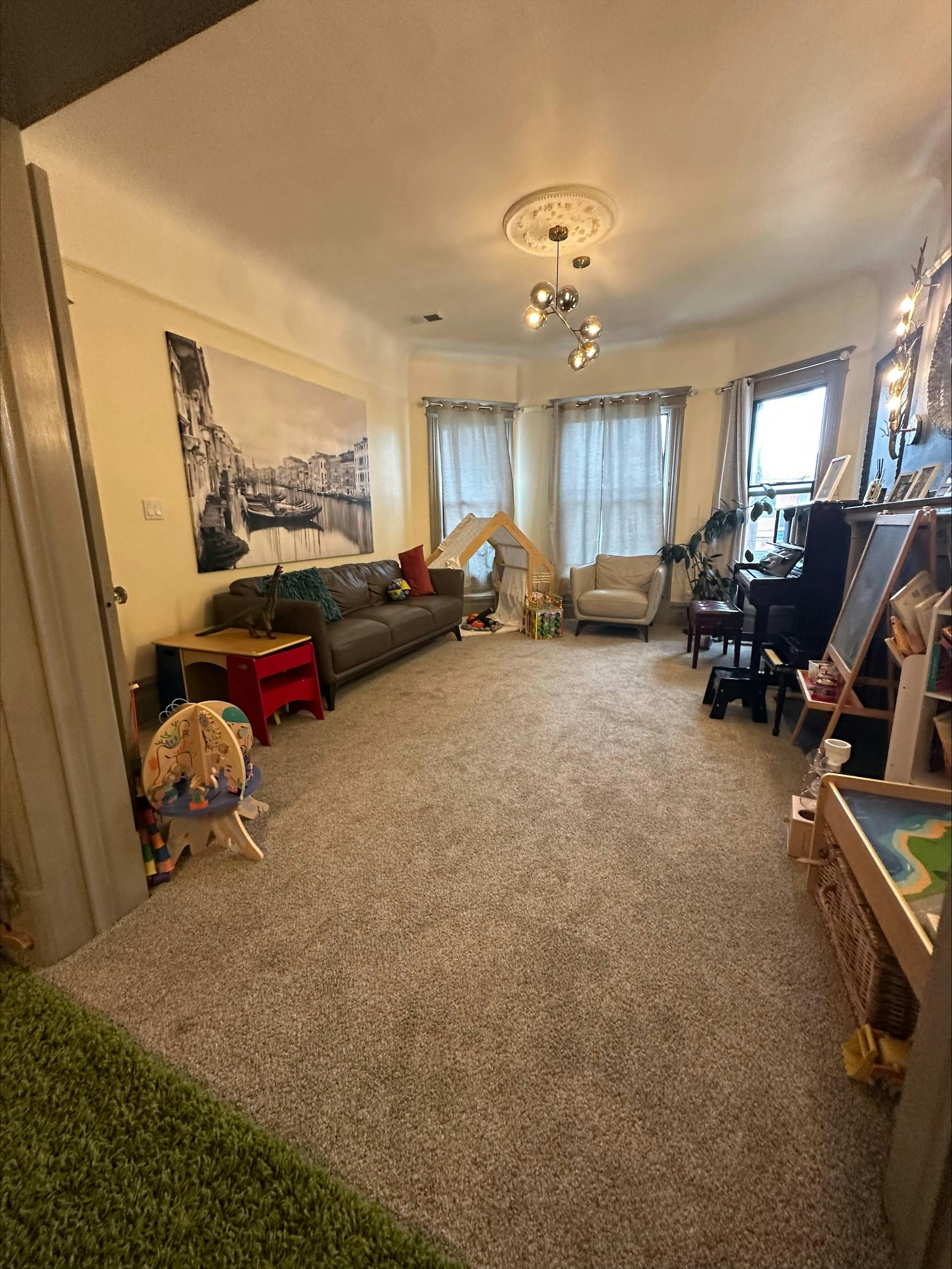 Living room with a sofa, armchair, and children's play area