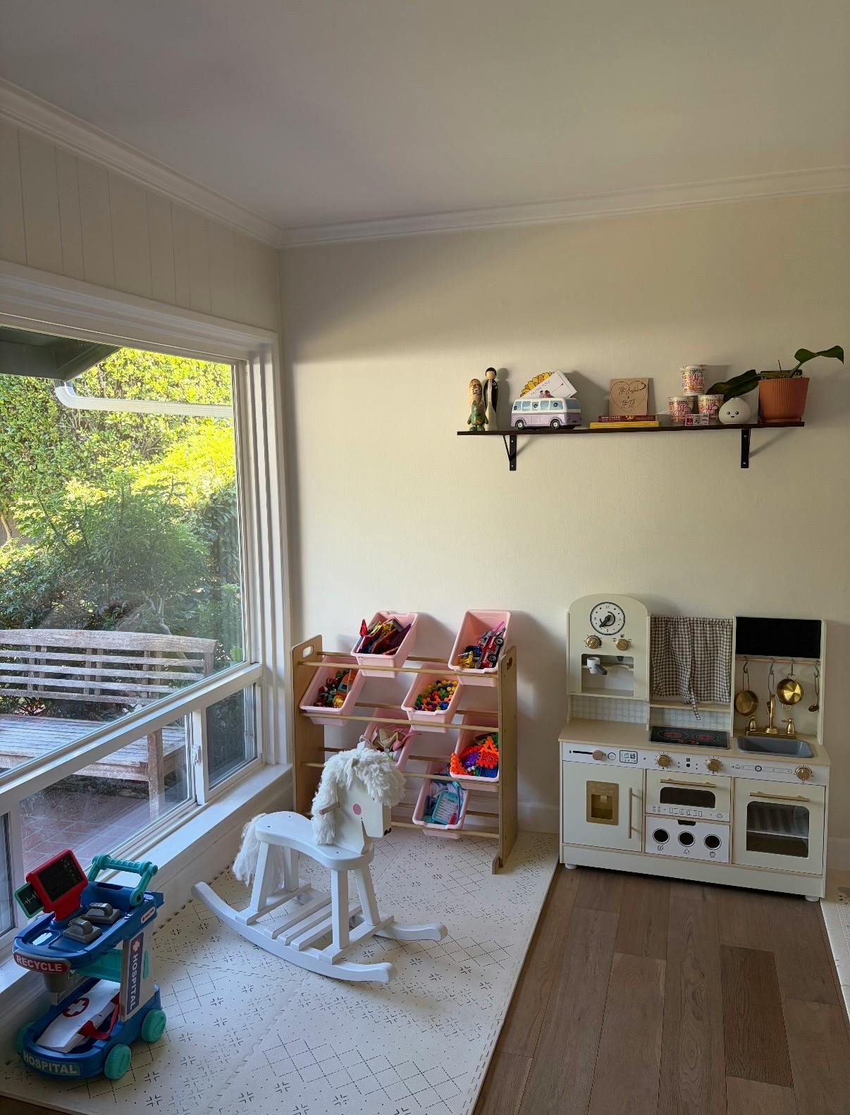 Playroom with a toy kitchen, rocking horse, and toy storage bins