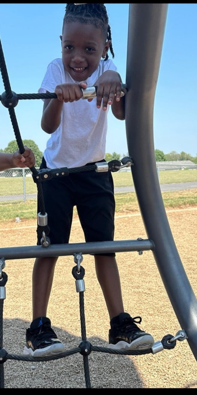 Child climbing on a rope structure at a playground