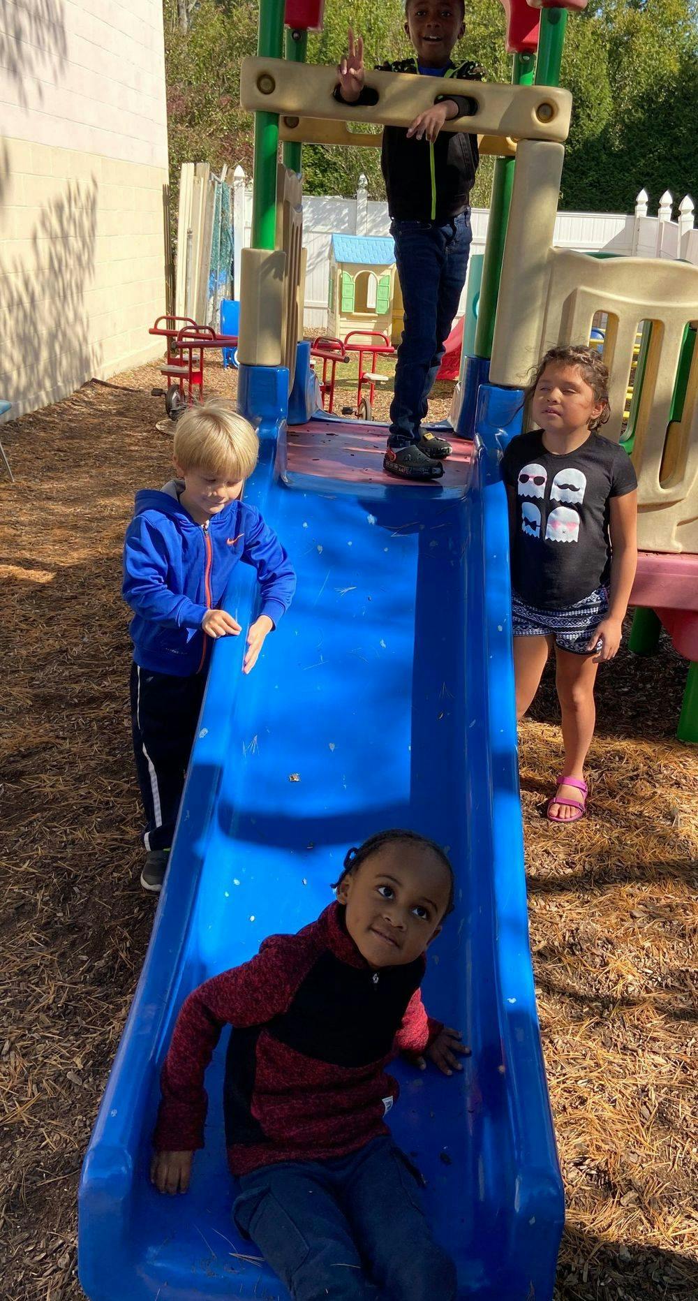 Children playing on a blue slide
