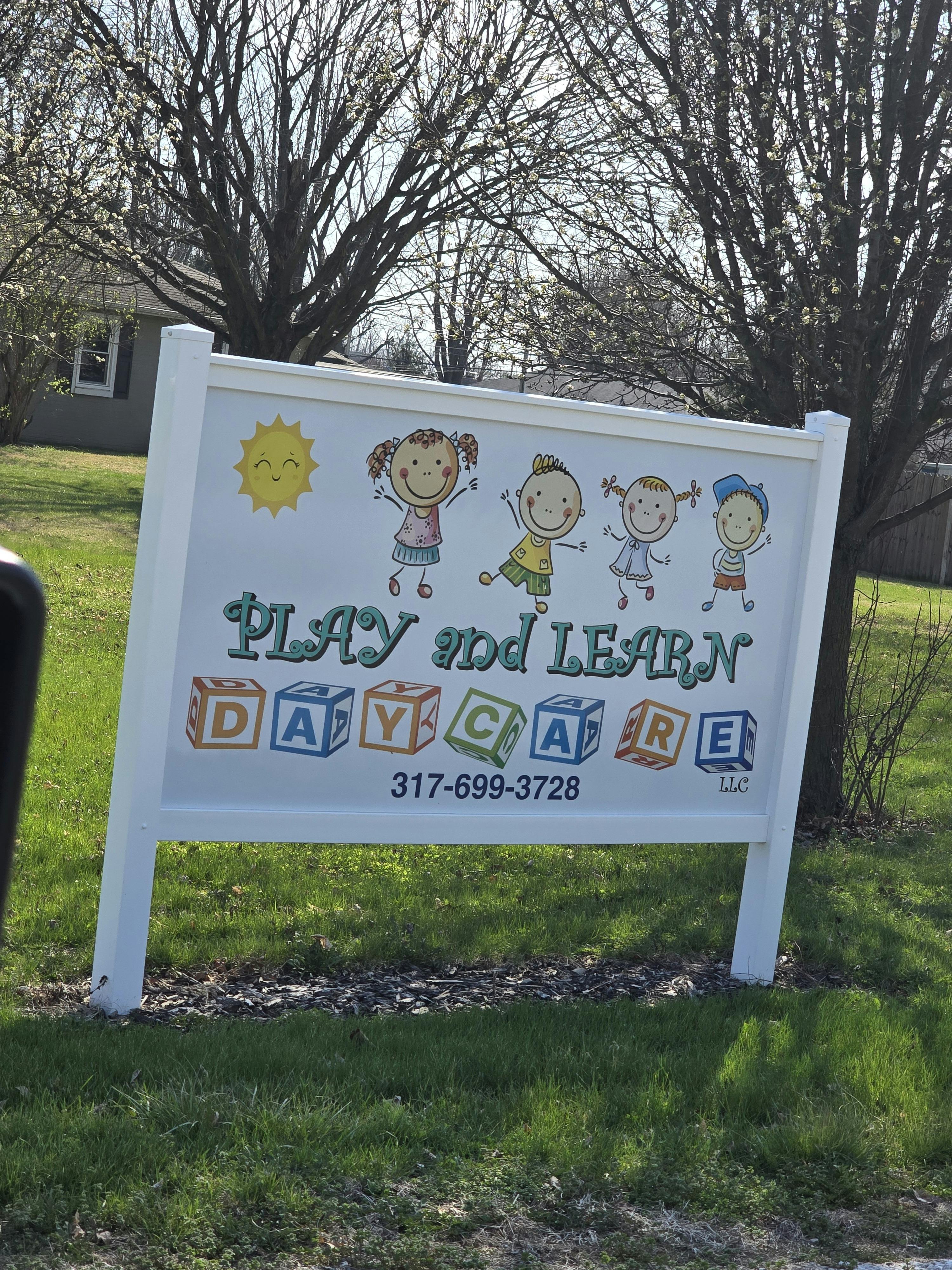 Sign with cartoon children and text "Play and Learn Daycare"