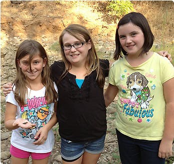 Three children standing together outdoors