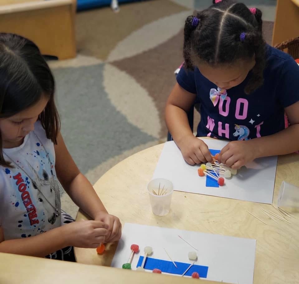 Two children making crafts at a table