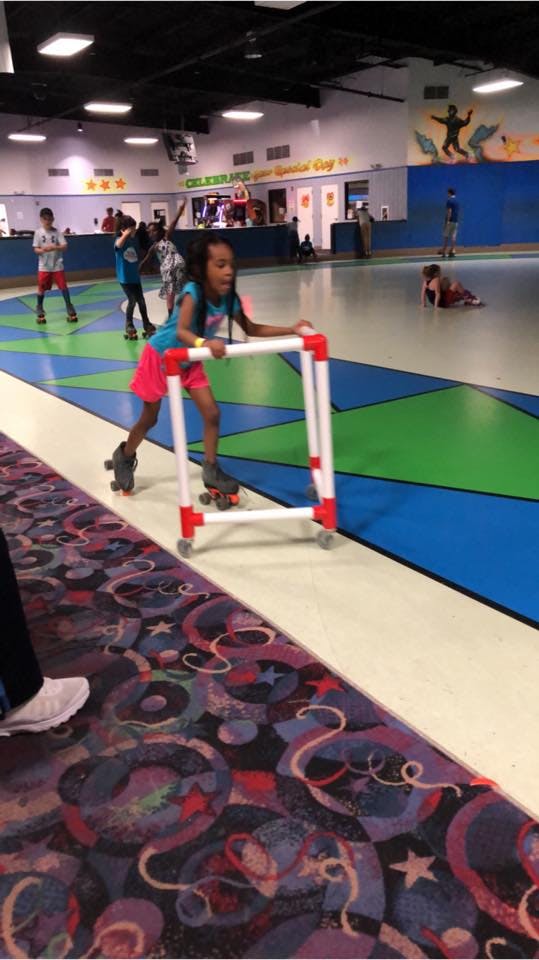 Child roller skating with a walking aid