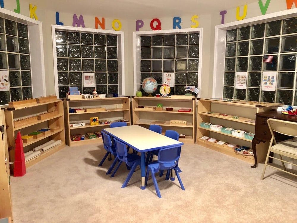 Classroom with small table and chairs, shelves with learning materials