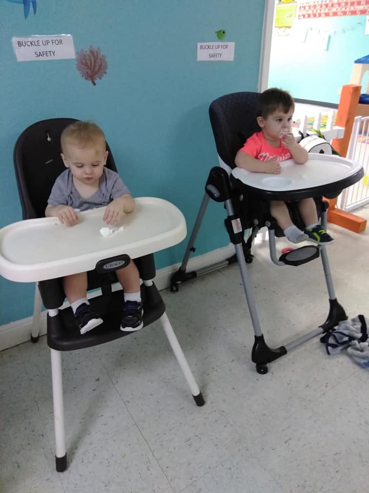Two children sitting in high chairs