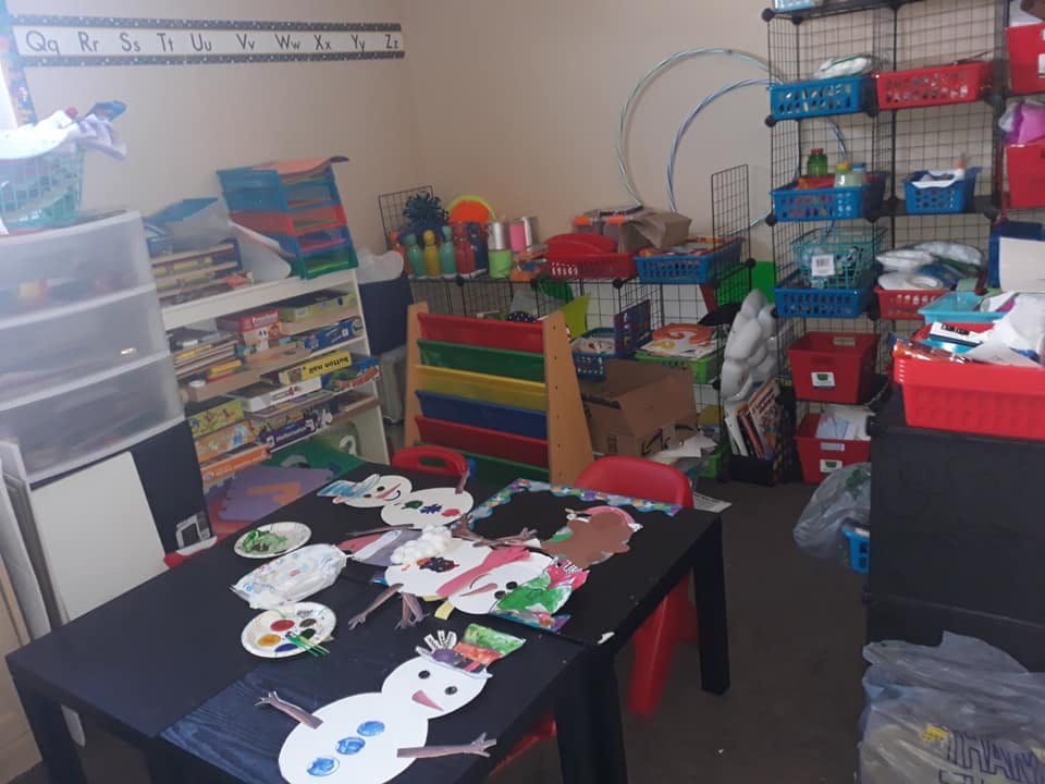 Table with children's art projects and paint palettes in a classroom