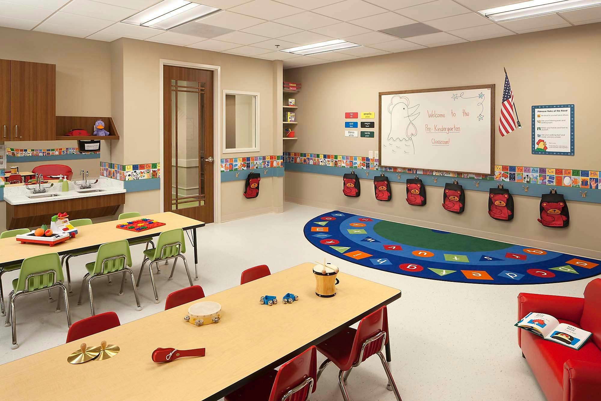 Classroom with tables, chairs, and a colorful rug