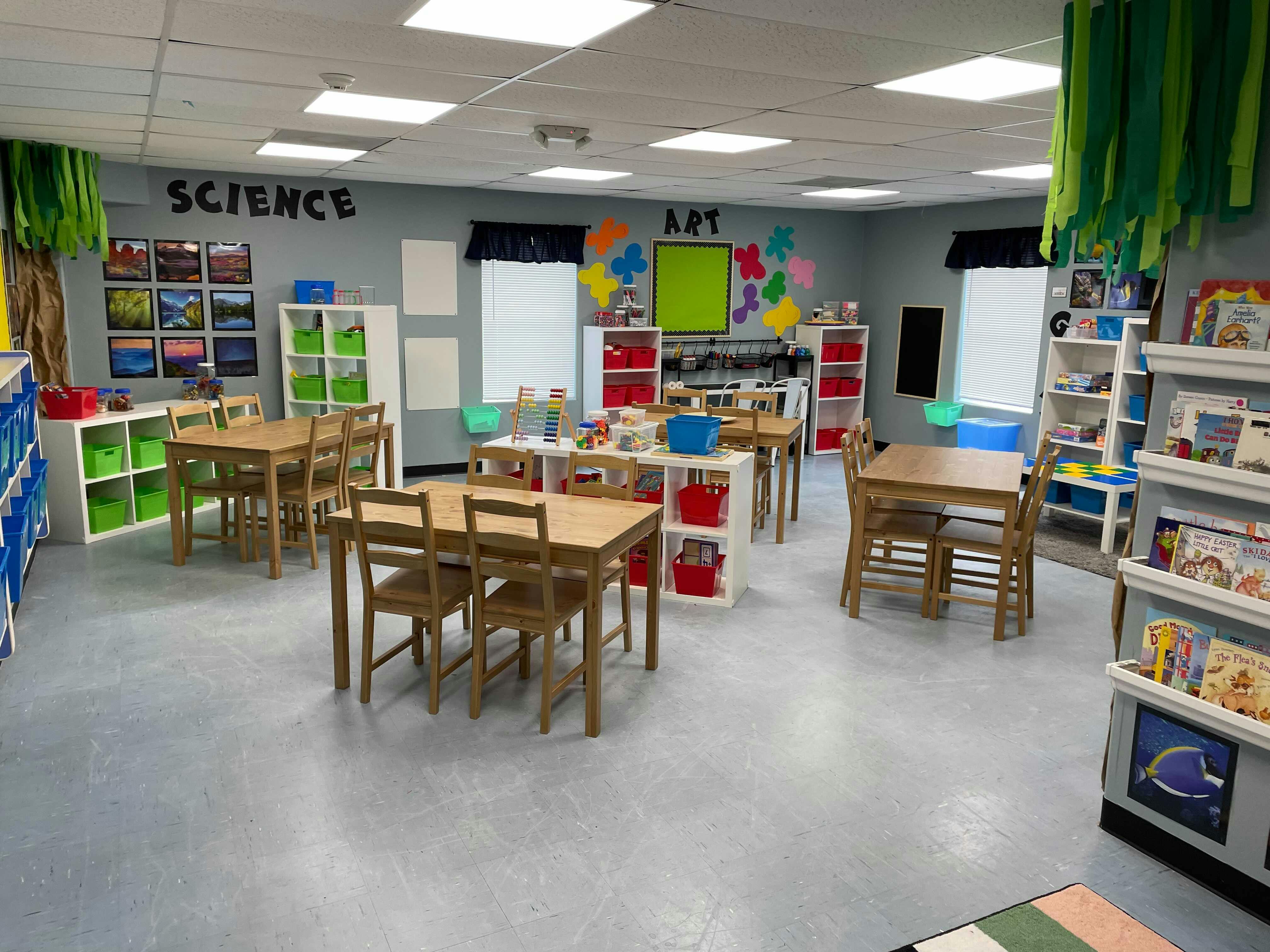 Empty classroom with tables and chairs, labeled "SCIENCE" and "ART"