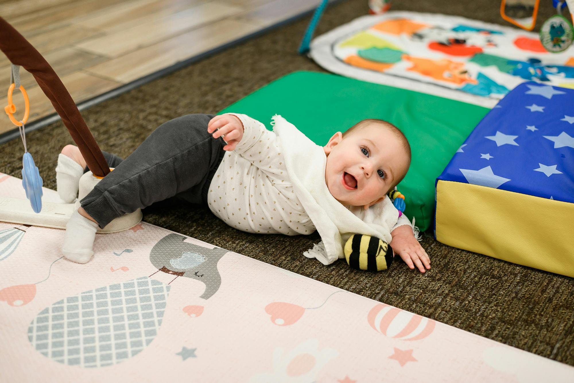 Child lying on a playmat with a toy