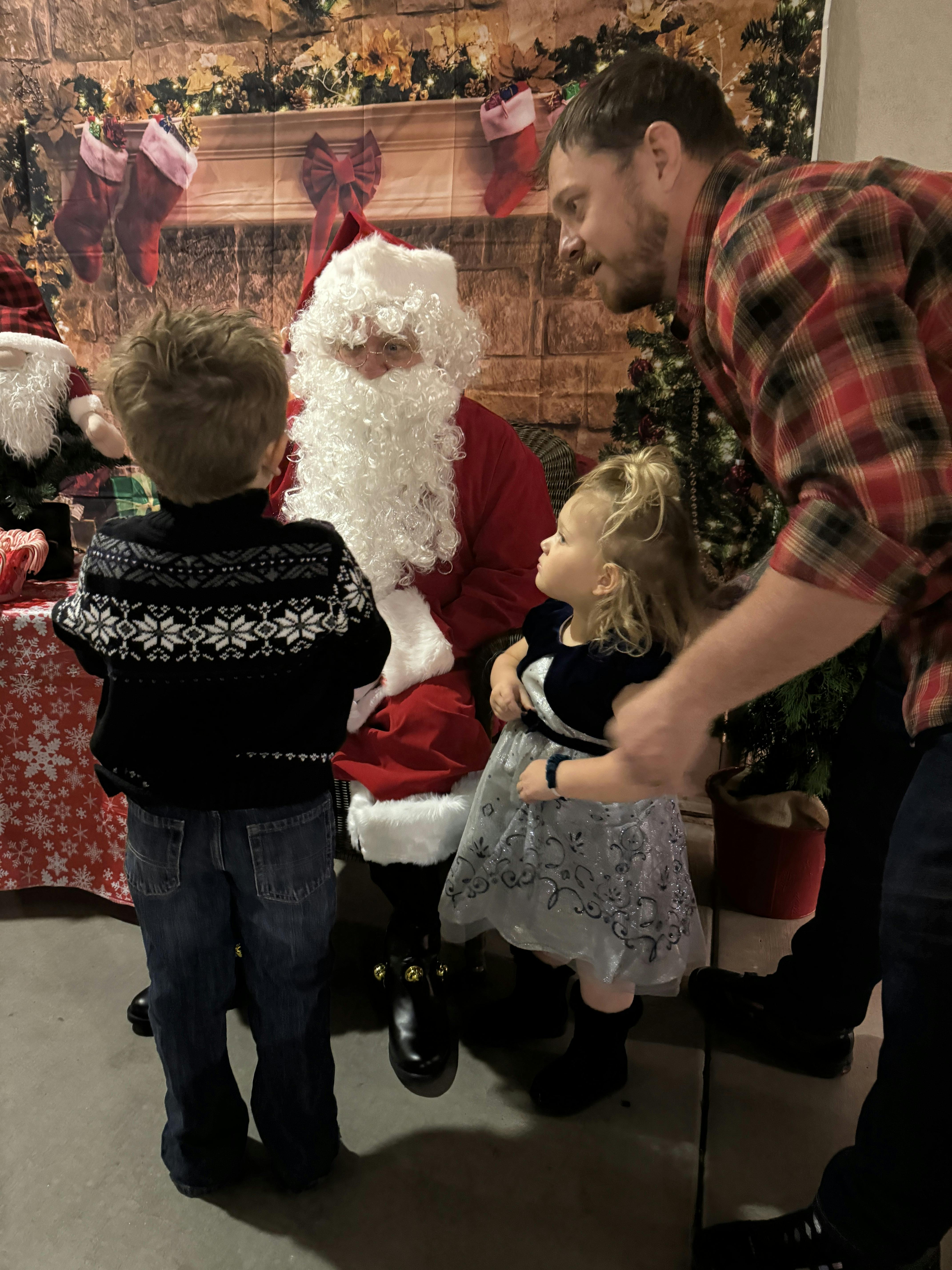 Santa Claus with two children and an adult