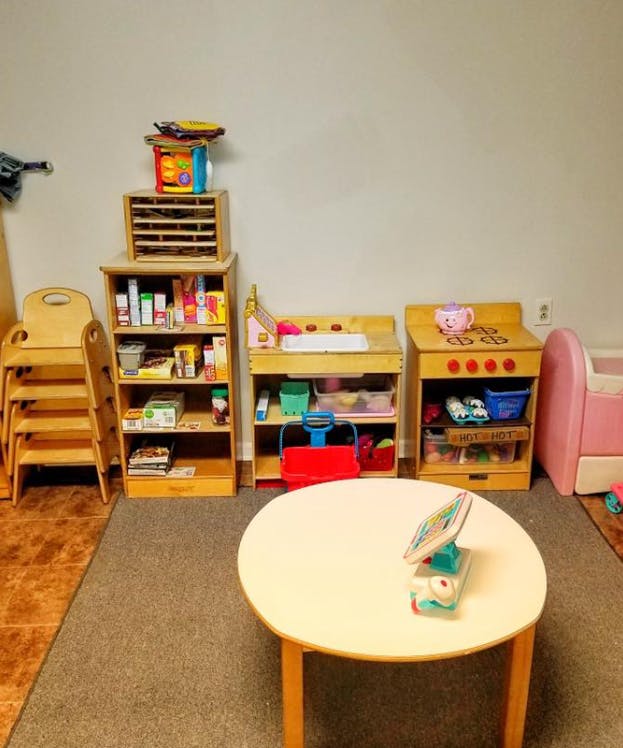 Children's play area with shelves, play kitchen, and small table