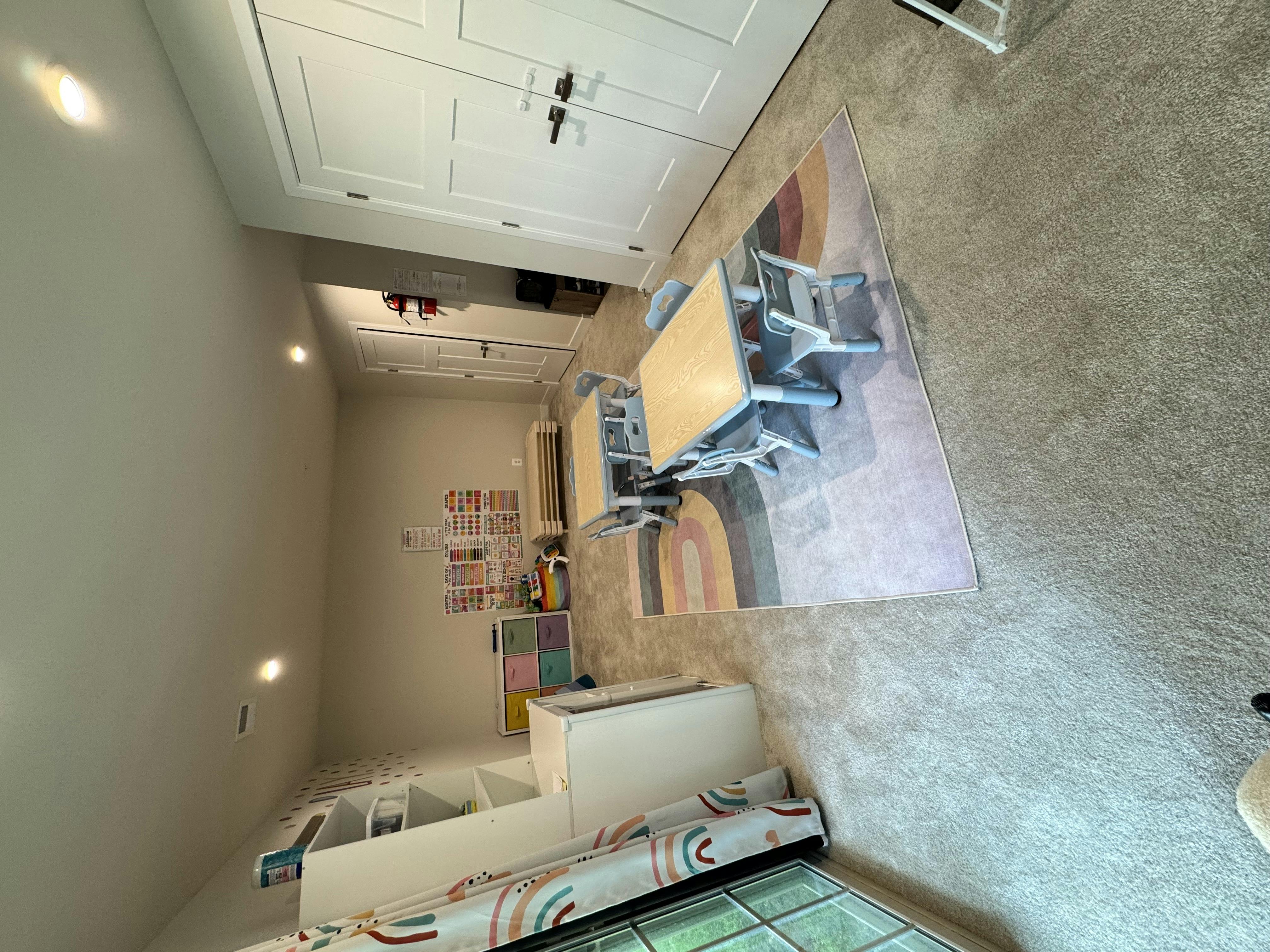 Classroom with two small tables and chairs on a rug