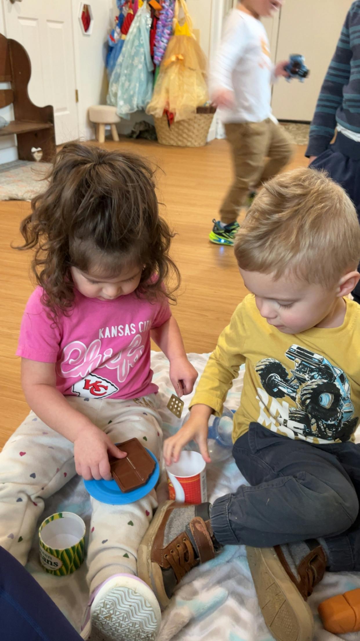 Two children playing with toy food on the floor