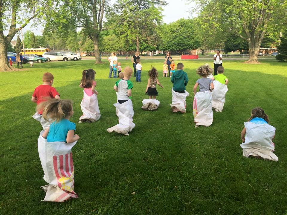 Children in sacks on a grassy field