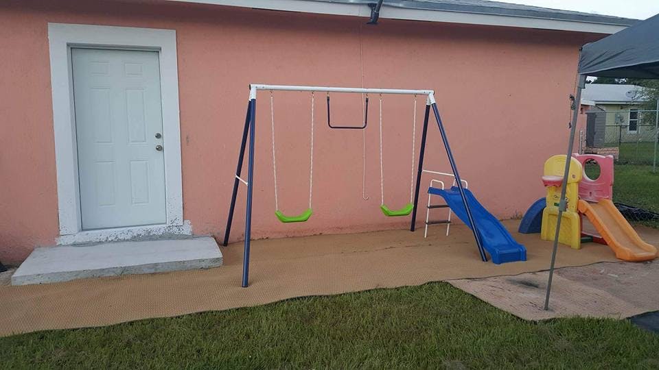 Swing set and slides next to a building