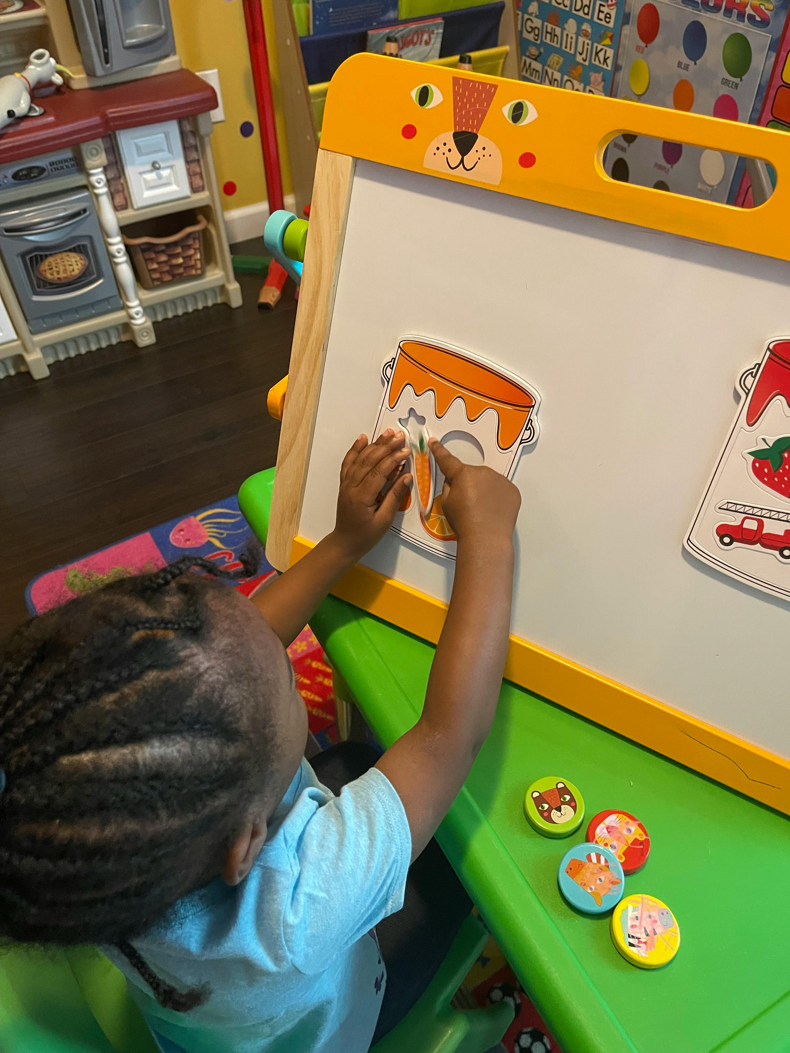 Child playing with magnets on an easel