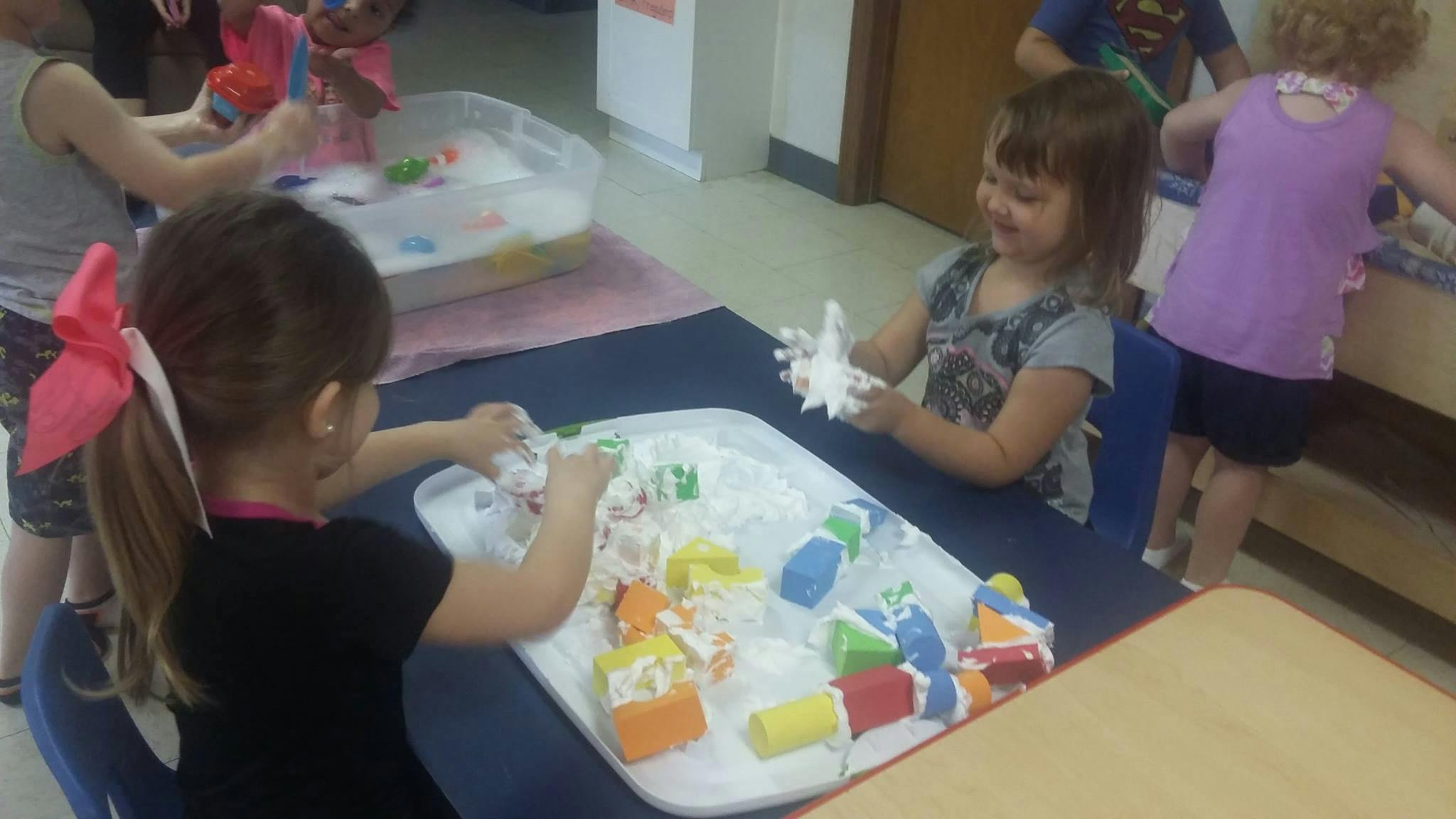 Children playing with foam and colorful blocks at a table