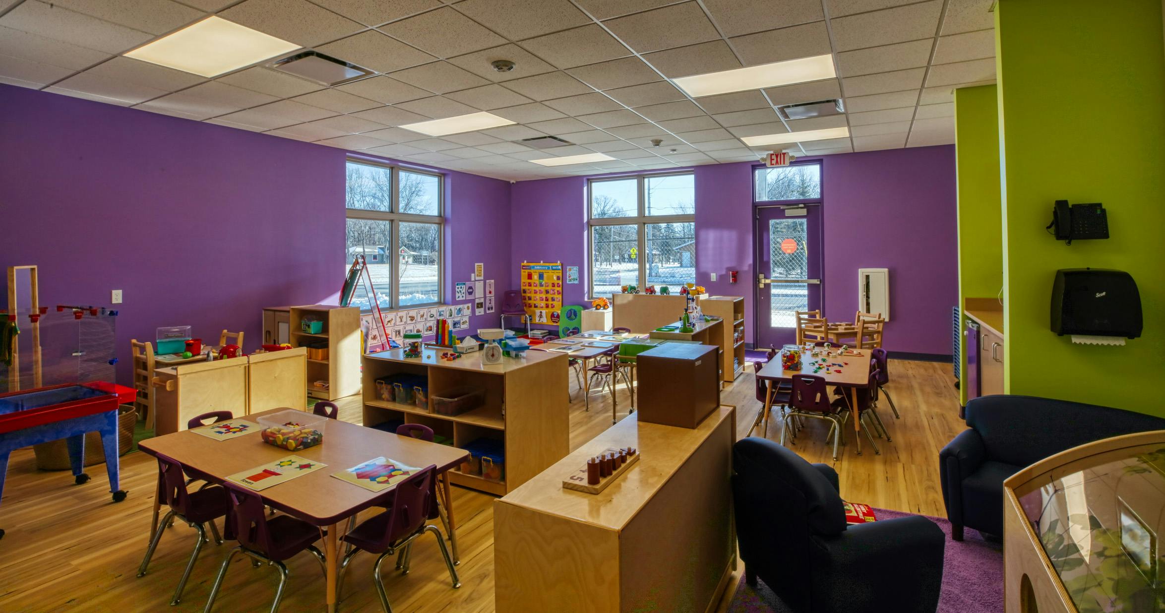An empty early childhood classroom with purple and green walls