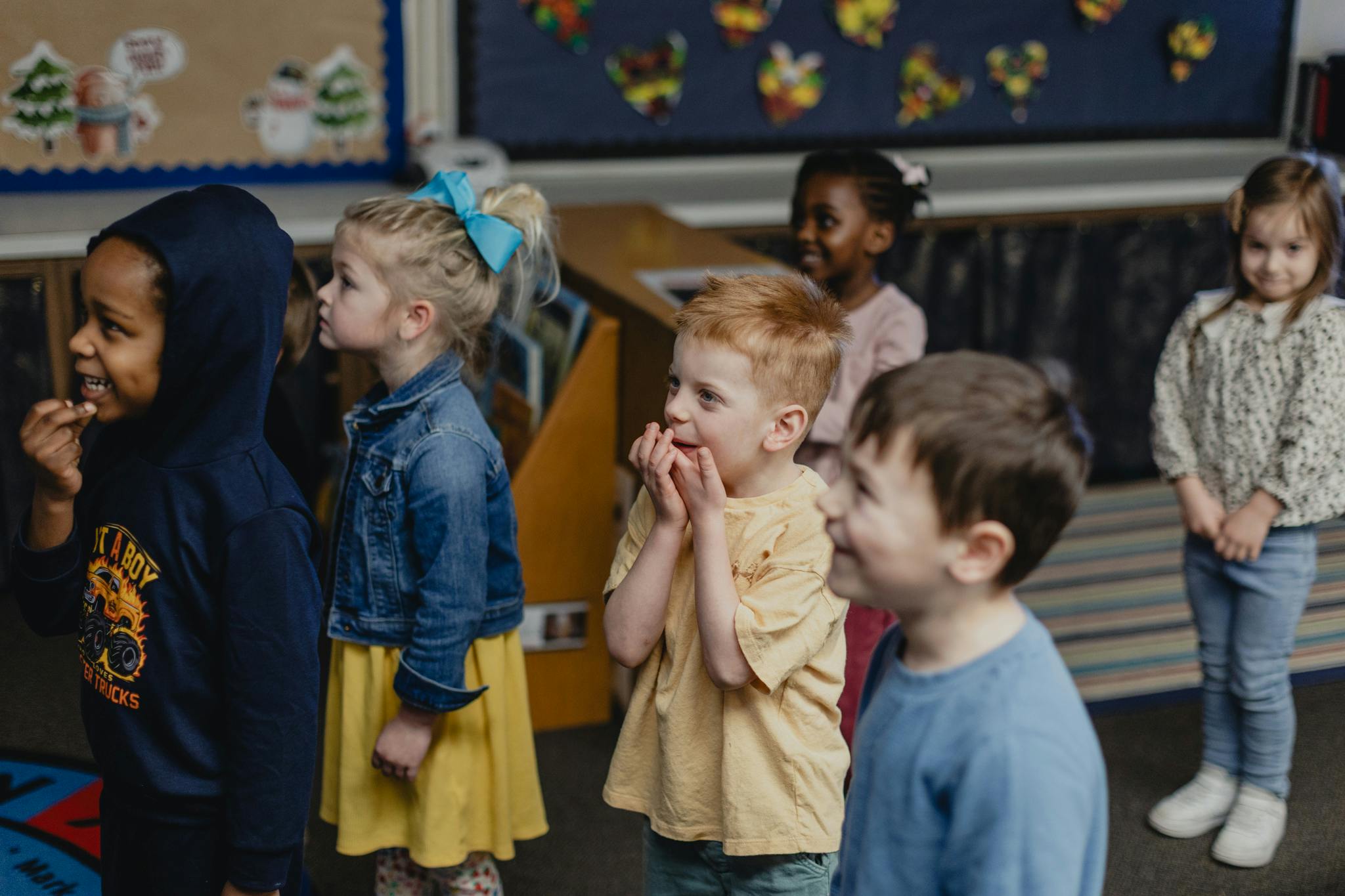Group of children standing and looking in a classroom