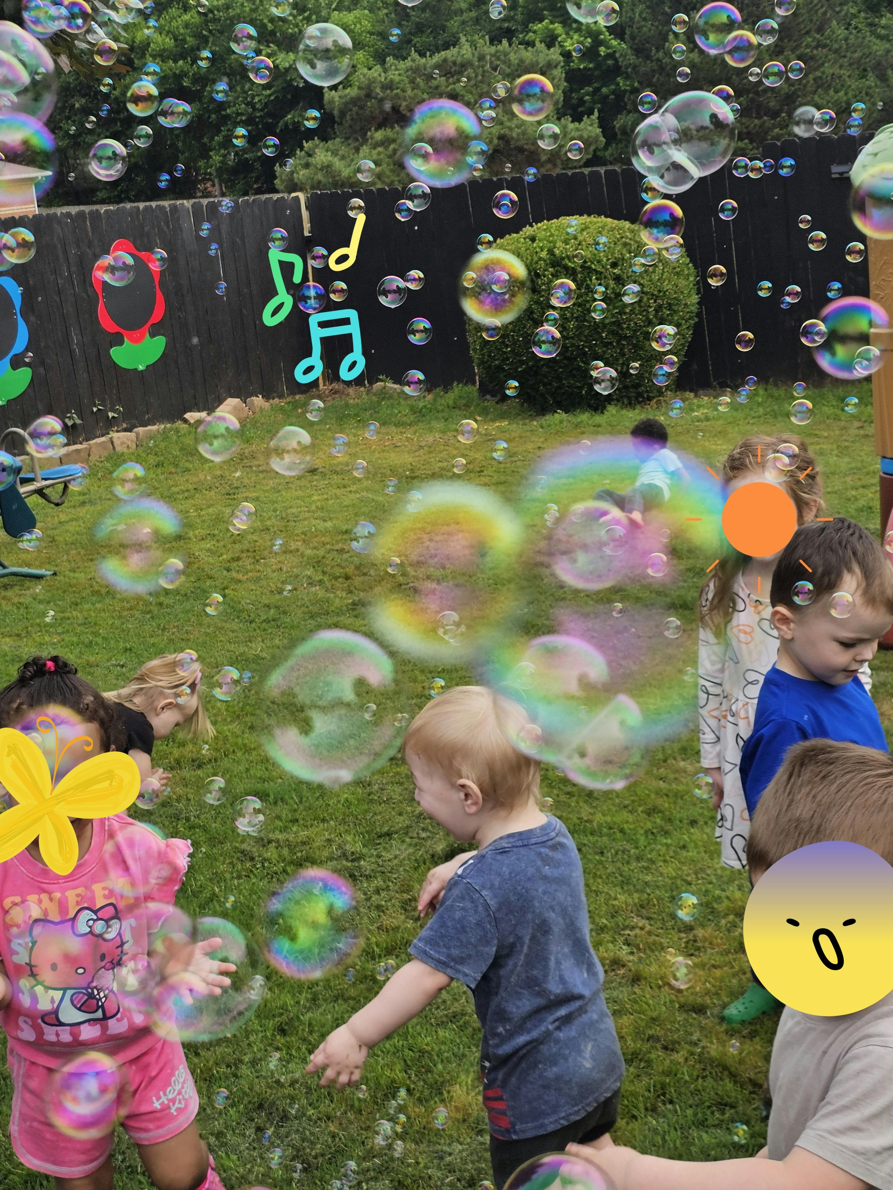 Children playing outdoors with many bubbles floating around them