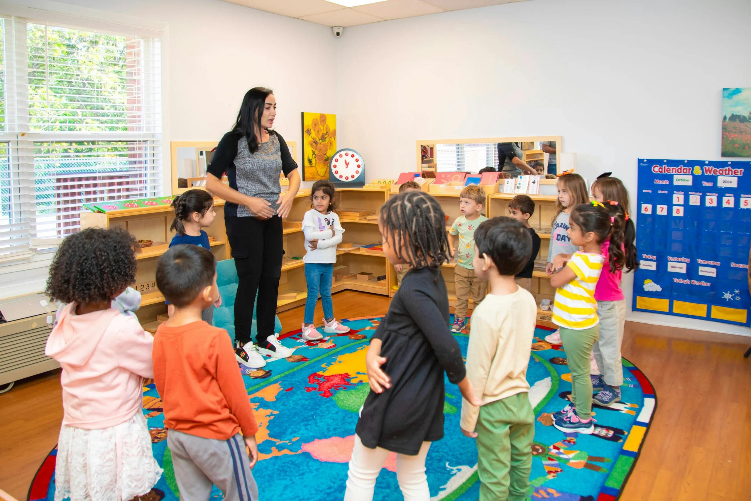 Teacher standing in a circle with a group of children in a classroom