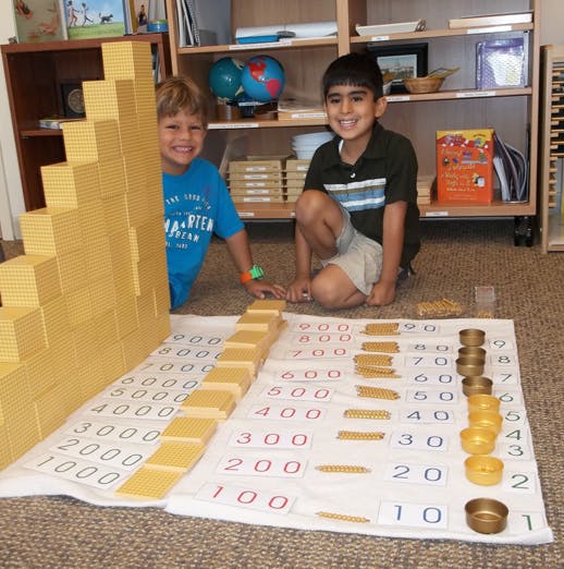 Two children playing with math blocks and number mats