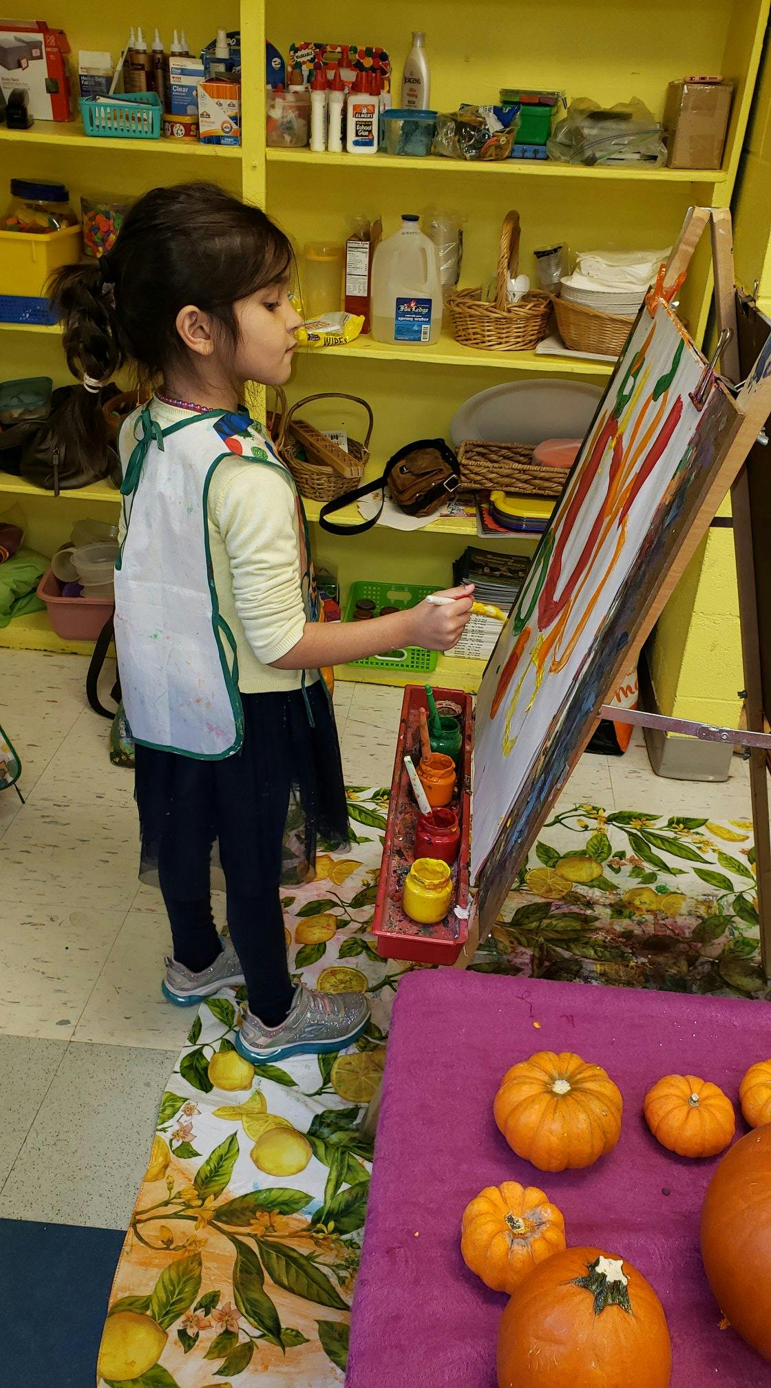Child painting on an easel