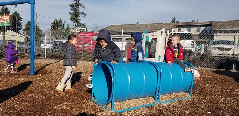 Children playing on a blue tunnel on a playground