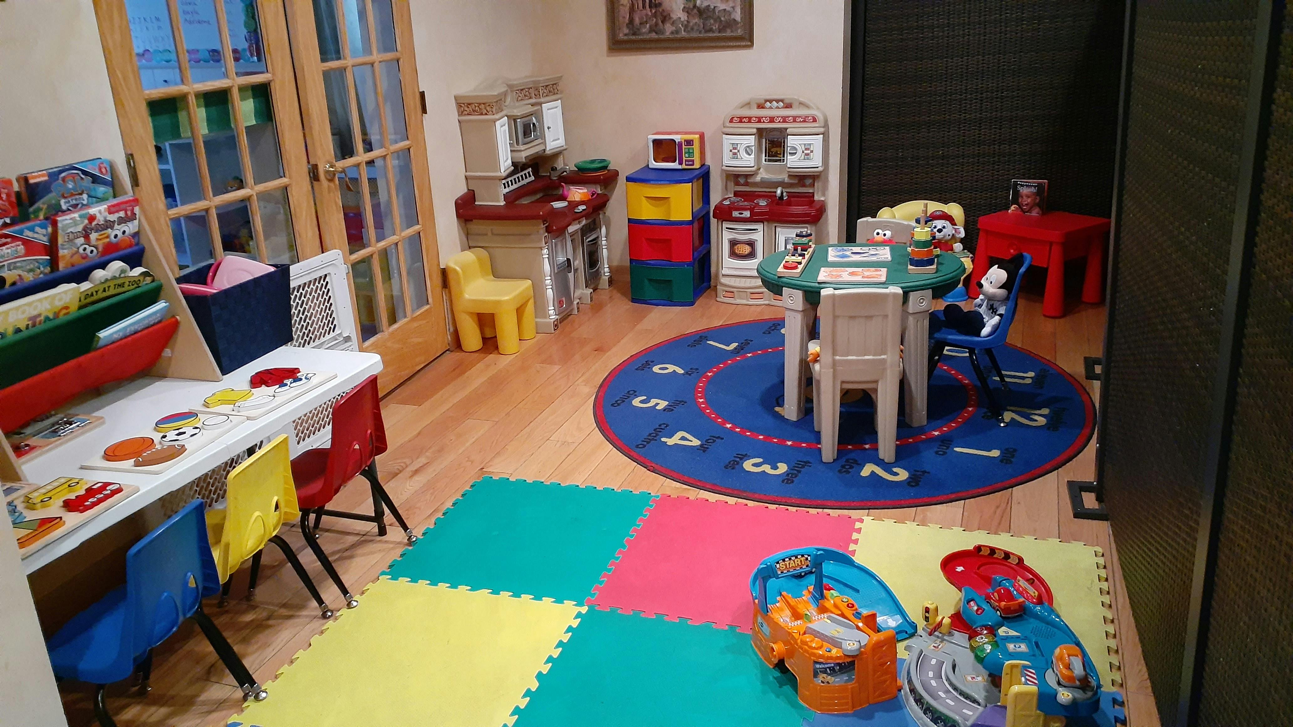 Playroom with small tables, chairs, and colorful floor mats