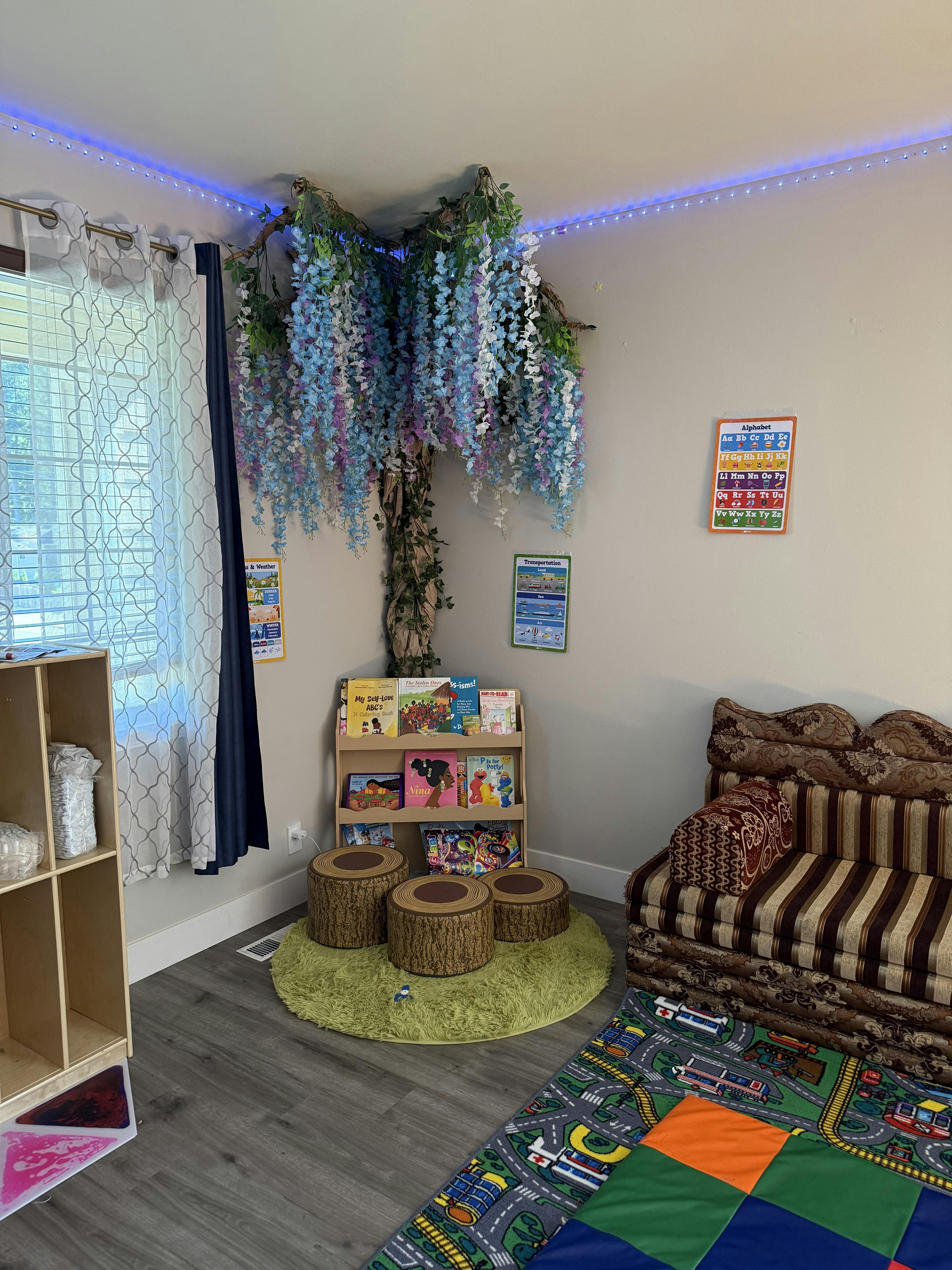 Reading corner with a bookshelf, tree decor, and stump stools on a rug
