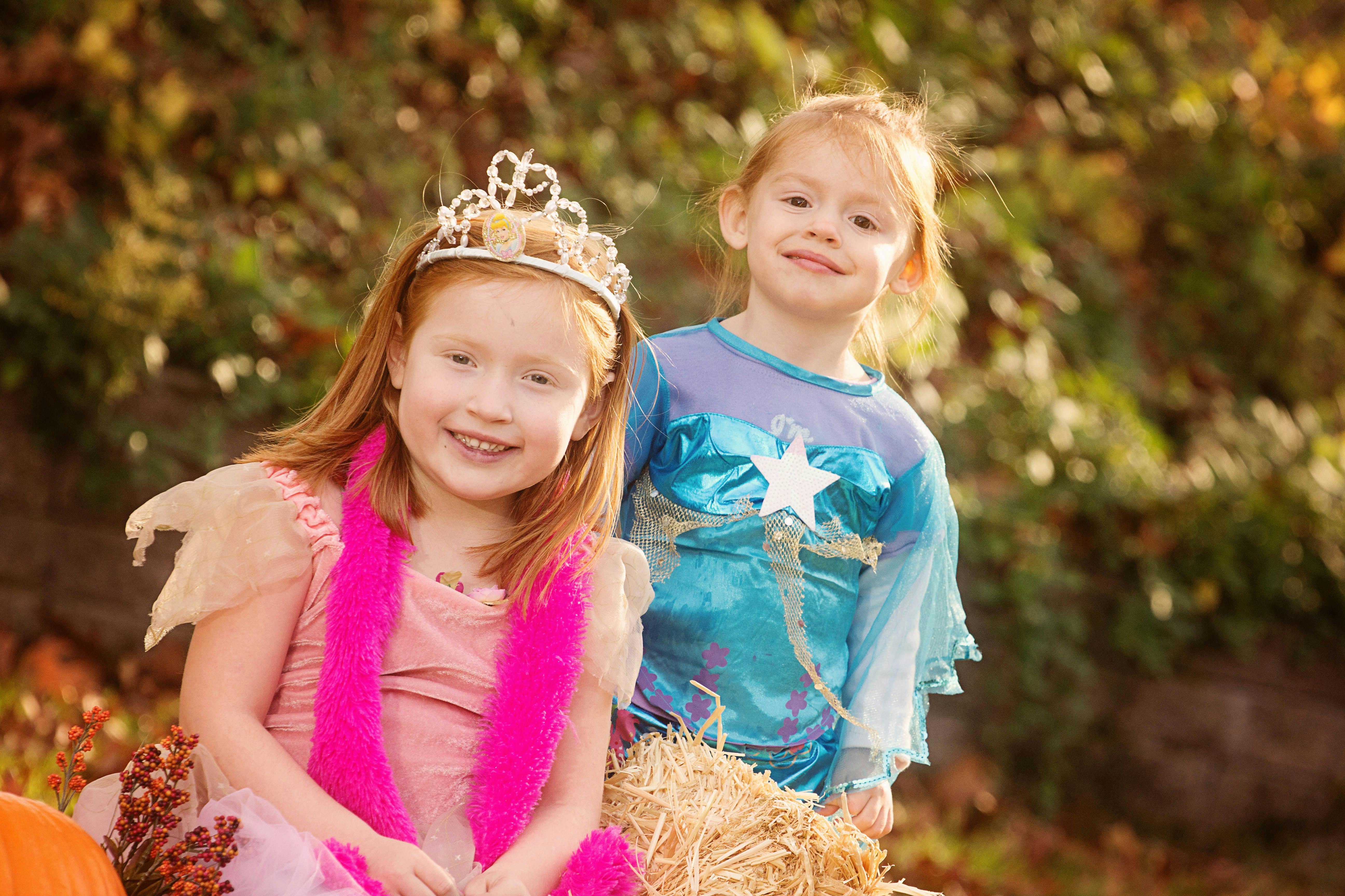 Two children in costumes, one wearing a tiara and the other a blue dress