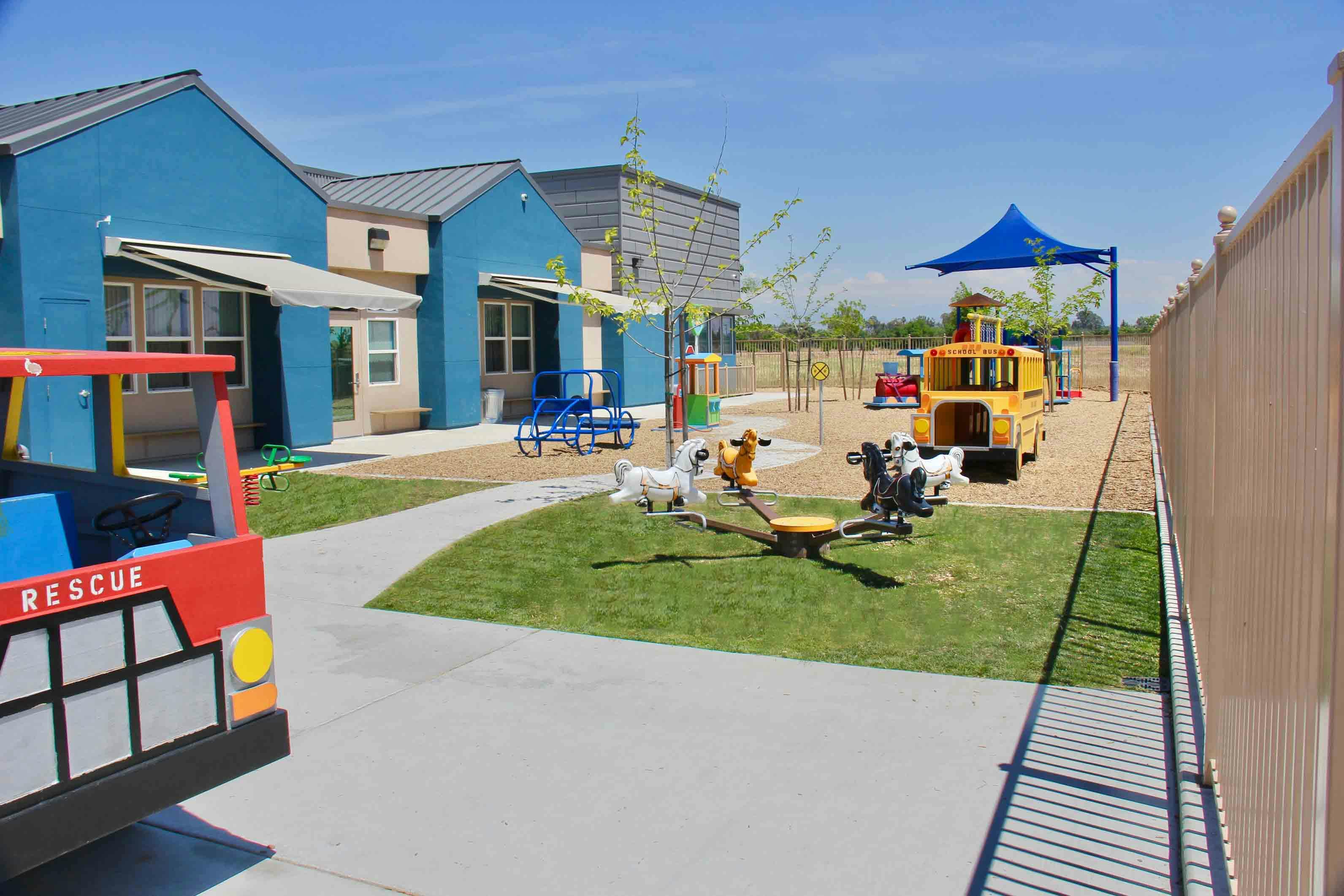 Playground with a red rescue vehicle and yellow school bus