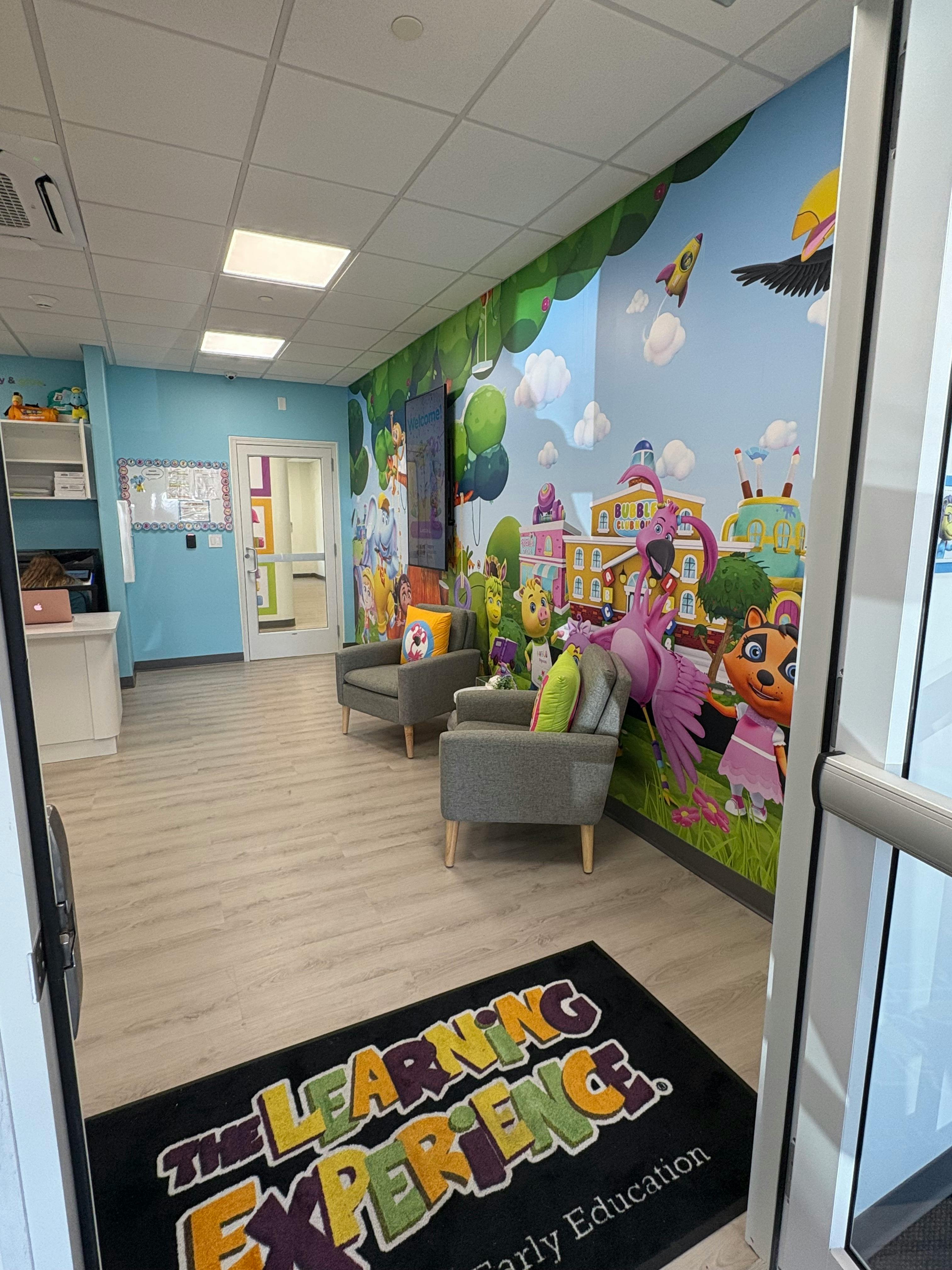 Waiting area with two chairs and a colorful mural on the wall