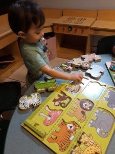 Child playing with a wooden animal puzzle