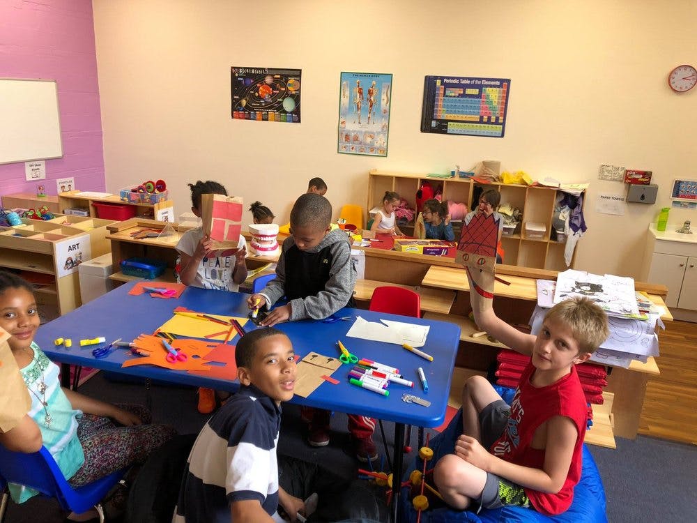 Children doing crafts at a table in a classroom