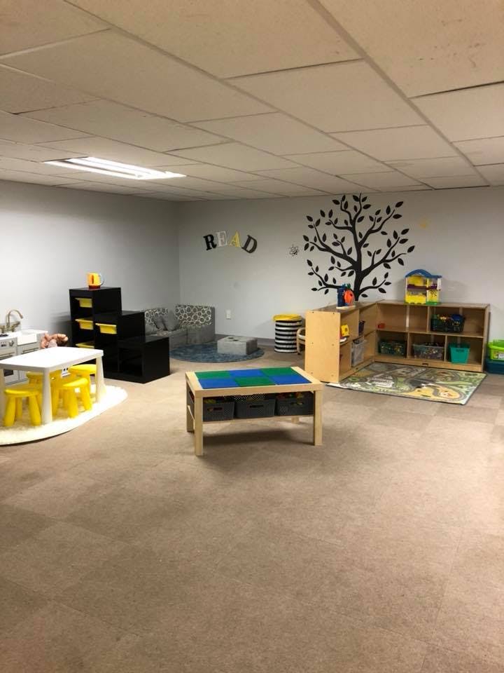 Playroom with small tables, chairs, and storage units