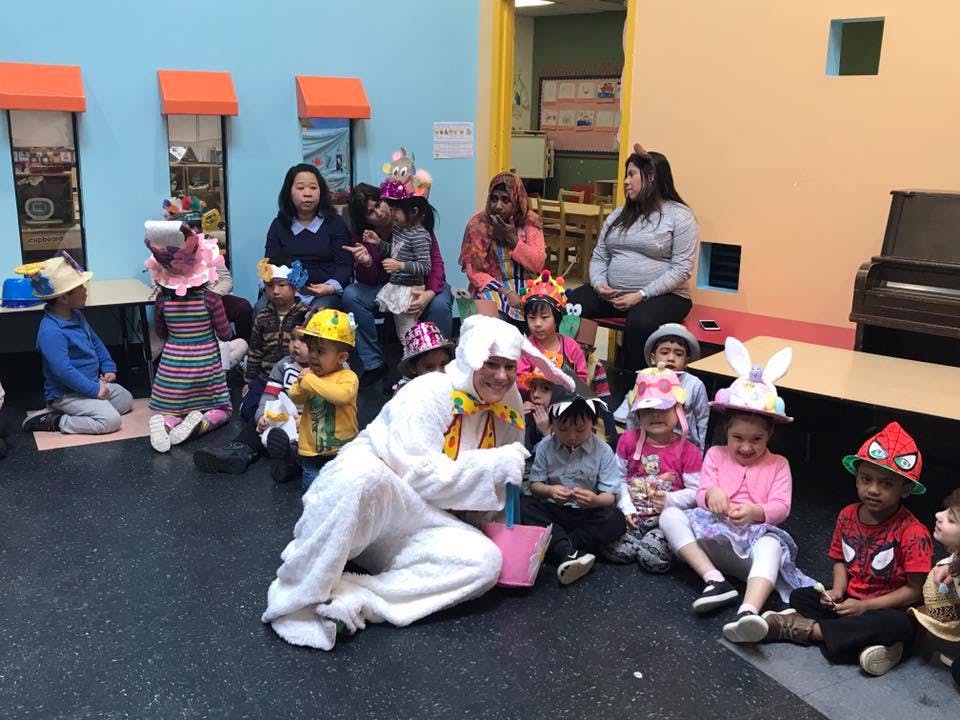 Person in bunny costume with children and adults in a room