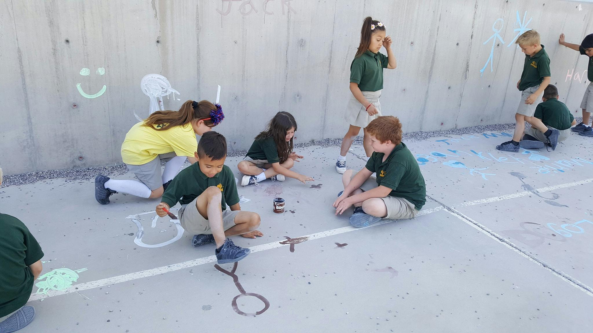 Children drawing with chalk on pavement