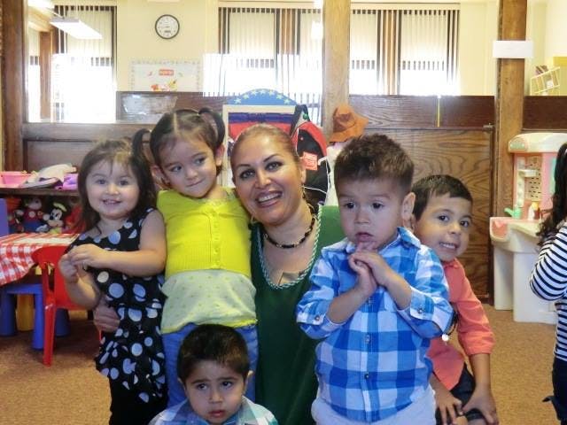 Person with five children in a classroom