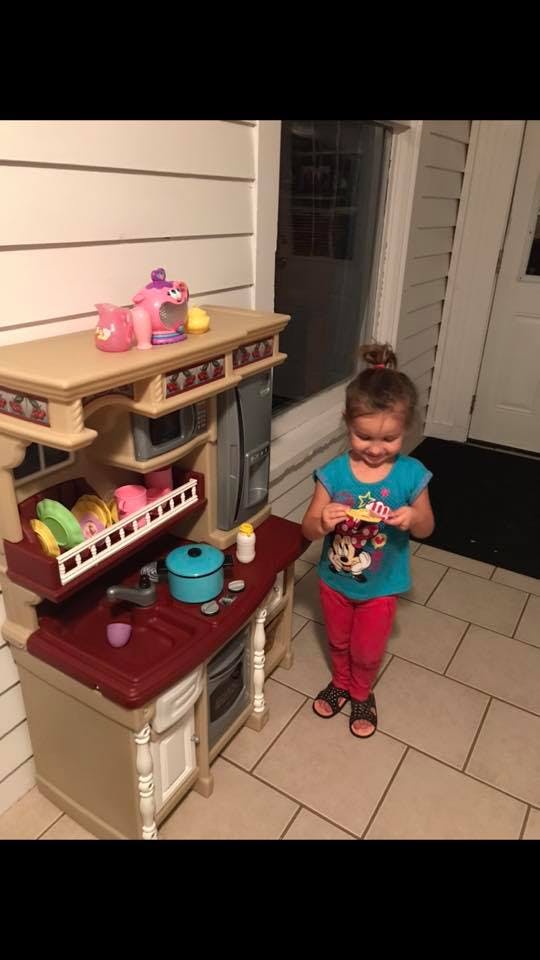 Child playing with a toy kitchen set