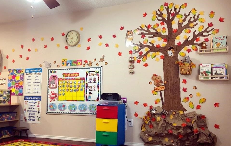 Classroom wall decorated with a large tree and falling leaves