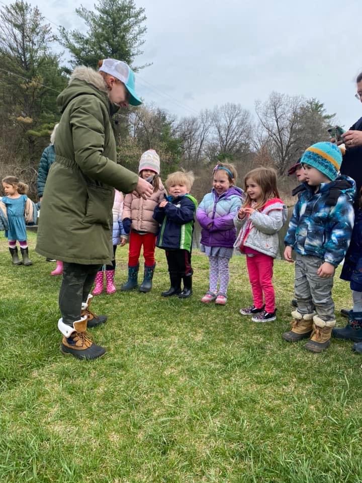Adult speaking to a group of children outdoors