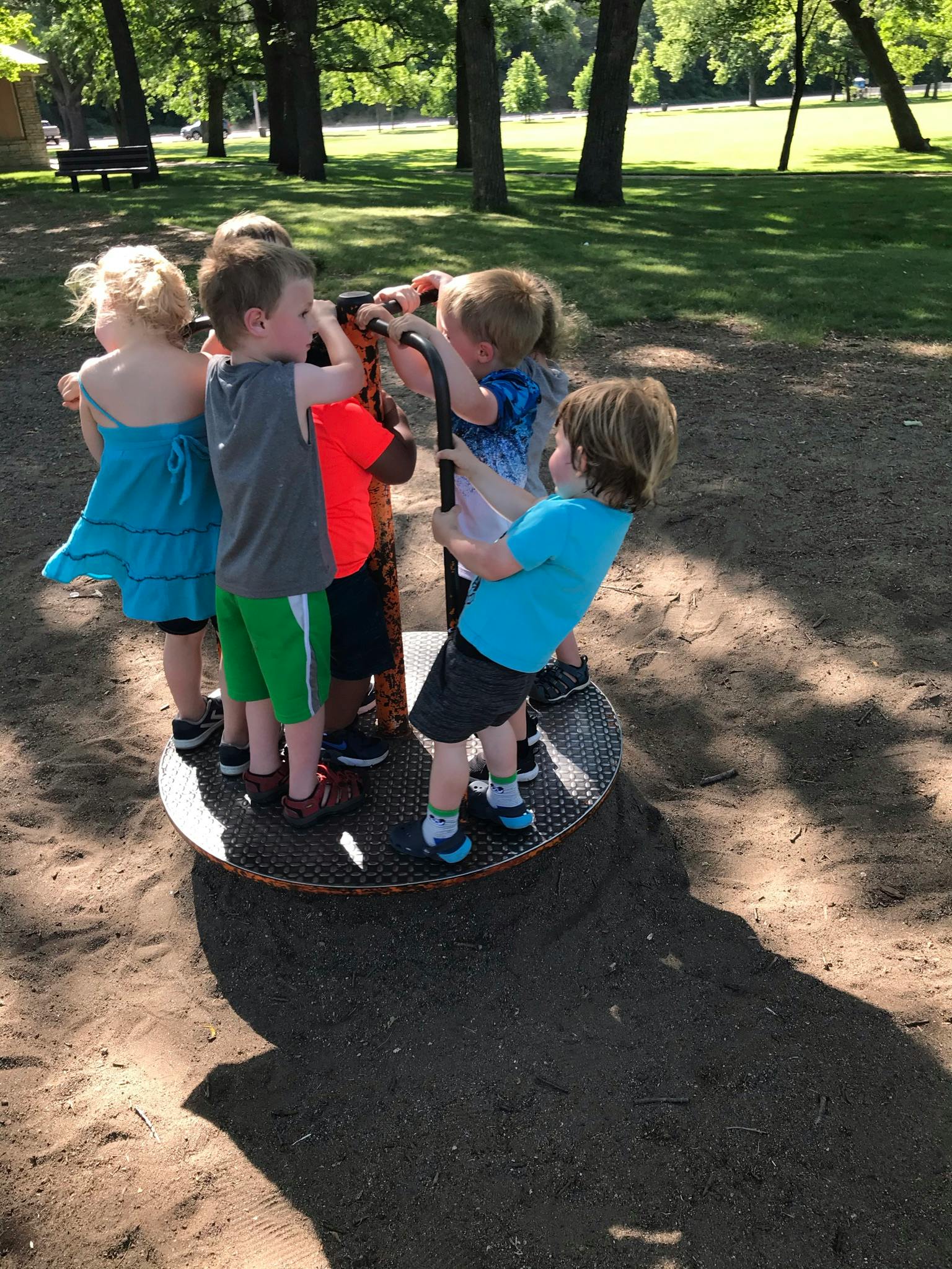 Children playing on a spinning playground ride