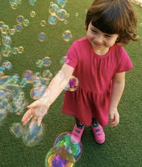 Child reaching for bubbles