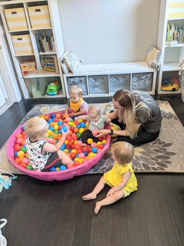 Adult and three children playing in a ball pit