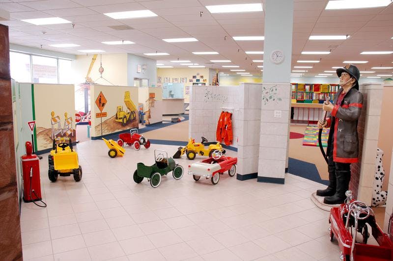 Playroom with ride-on toys and a firefighter statue